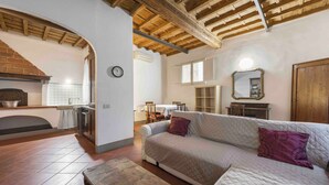 A cozy living room with a fireplace, a sofa, and a wooden table. - Borgo Allegri Palace by MMega (Florence)