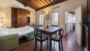 A room with a bed, a dining table, and a kitchen area. - Borgo Allegri Palace by MMega (Florence)