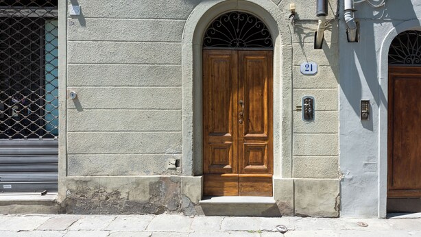 A building with a wooden double door, a number 21 sign, and a metal gate. - Borgo Allegri Palace by MMega (Florence)