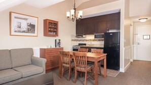 A compact living space with a kitchenette, dining area, and a sofa. - Ski-In Mountain Suite | Cozy Escape (West Dover)