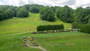 A lush green landscape with a gazebo, a stone pathway, and a well-maintained lawn. - King Room | Ski-In Resort Stay (West Dover)