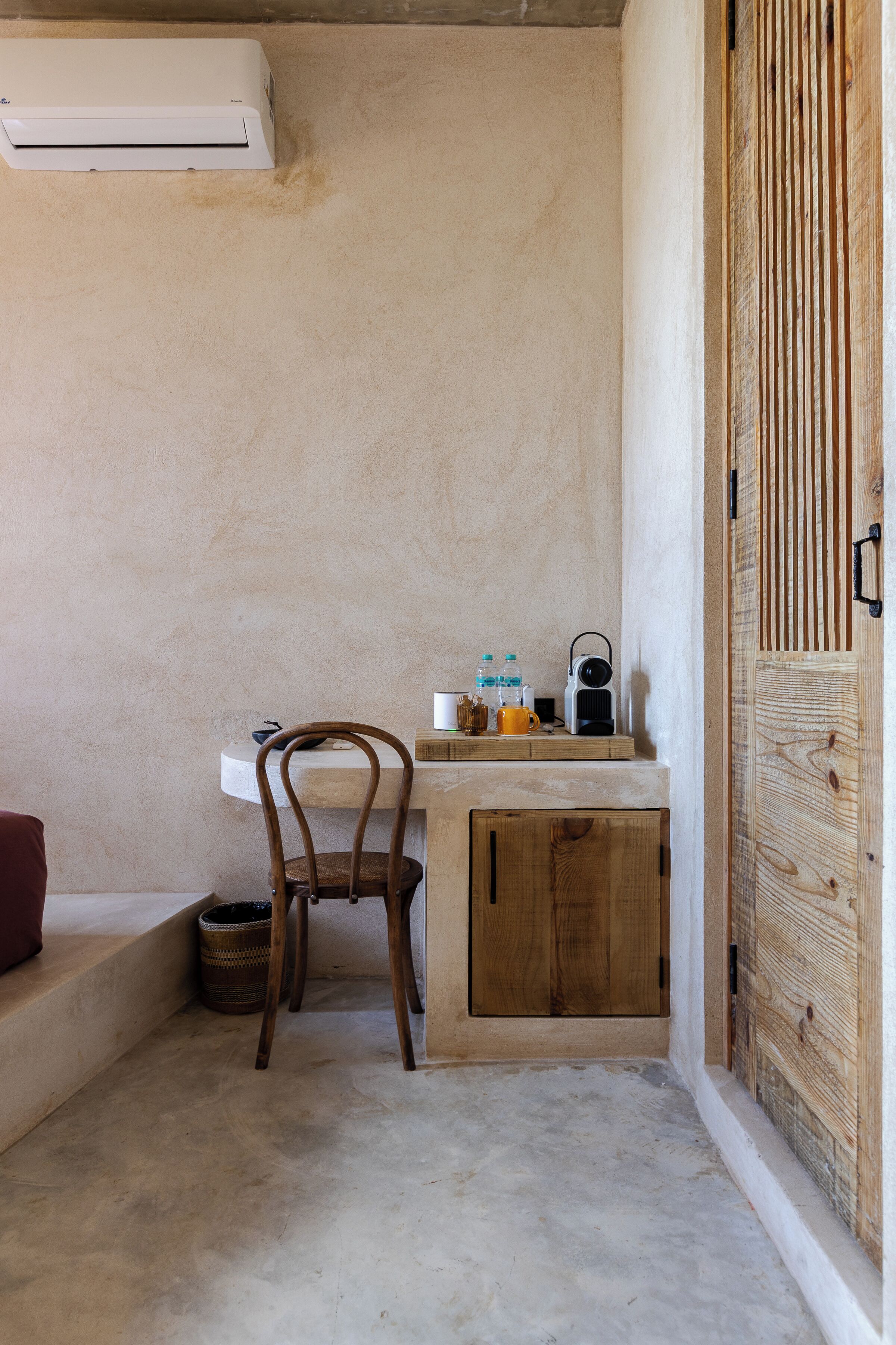 A small, rustic bathroom with a wooden chair, a sink, and a wooden cabinet.