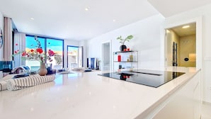 A modern living room with a large glass table, a sofa, and a bookshelf. - Villa with private pool and Jacuzzi (San Javier)