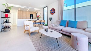 A modern living room with a sofa, coffee table, and dining area. - Villa with private pool and Jacuzzi (San Javier)