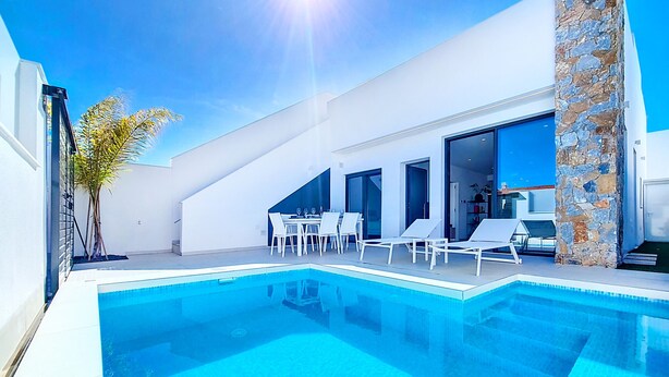 A modern outdoor swimming pool with lounge chairs and a dining area. - Villa with private pool and Jacuzzi (San Javier)