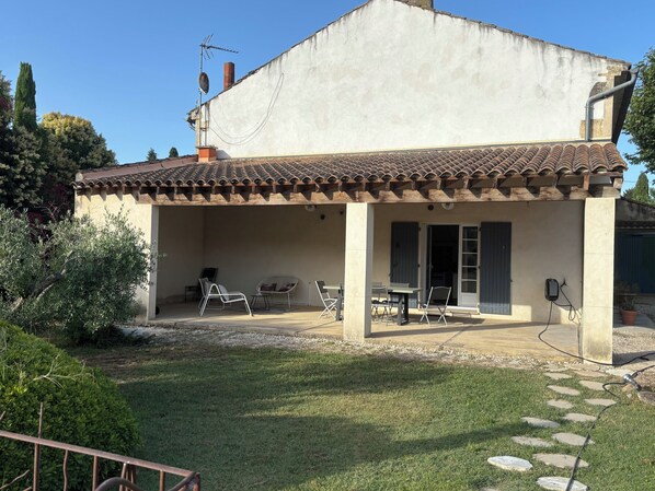 A house with a covered patio, outdoor seating, and a garden. - Beautiful Provençal farmhouse with swimming pool. (Châteaurenard)