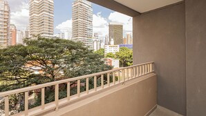 Ein Balkon mit Blick auf hohe Gebäude und Bäume.