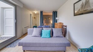 A modern living room with a grey sofa, a dining table, and a kitchen area in the background. - Les Perlières: close to the beach, center (Arcachon)