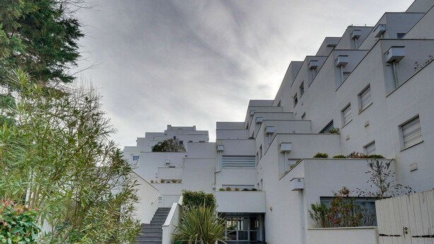 A modern building with a flat roof, multiple windows, and a staircase leading to the entrance. - Les Perlières: close to the beach, center (Arcachon)