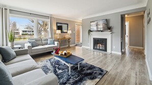 A modern living room with a sofa, coffee table, and fireplace. - Spacious 7-bedroom house with WiFi and MASSIVE backyard in marvelous Plymouth (Plymouth)