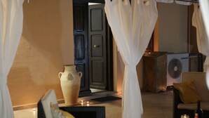 Una stanza con un'ampia boccia di fiori, una ventola e una poltrona con cuscino.