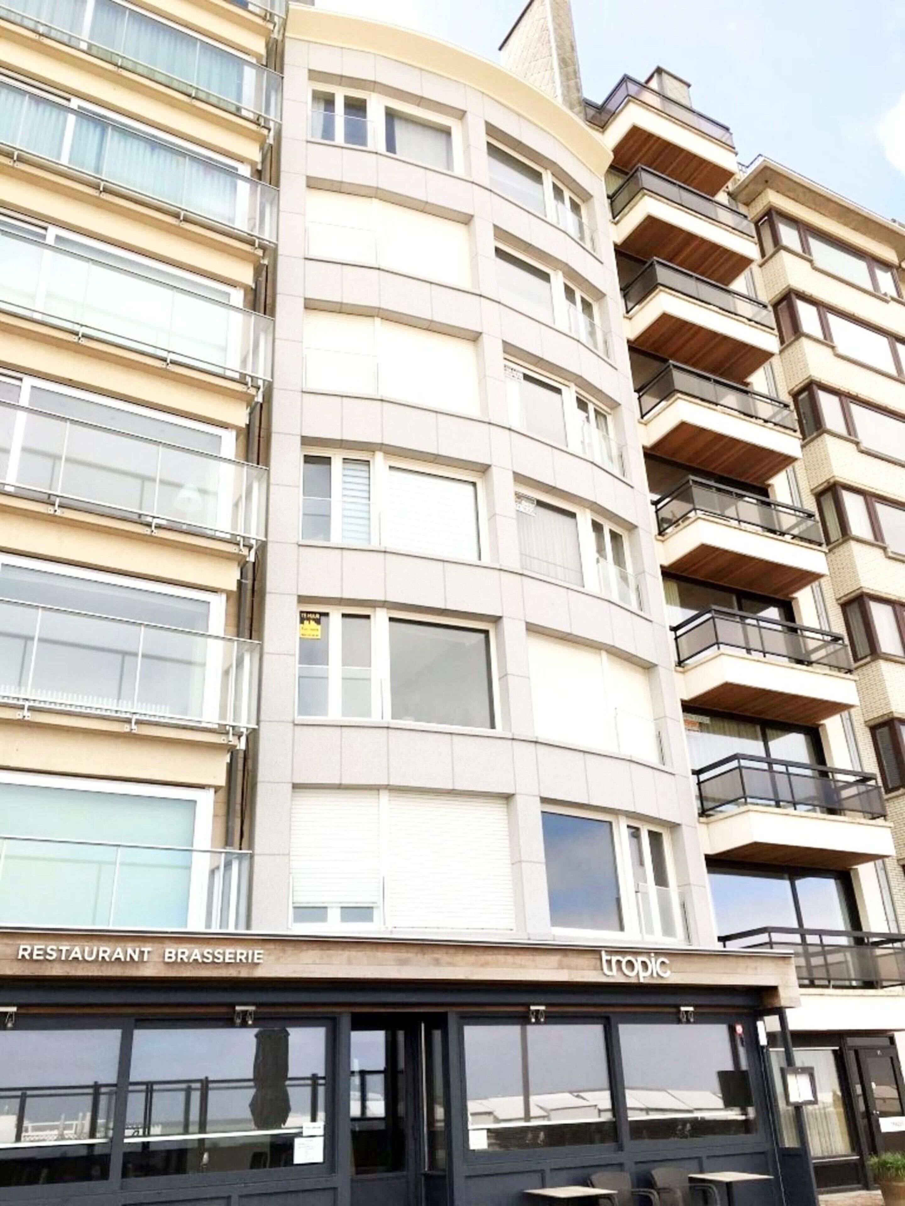 A multi-story building with a restaurant named "Restaurant Brasserie" on the ground floor.