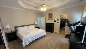 A bedroom with a bed, a dresser, a treadmill, and a closet. - Large private home near campus (Auburn)