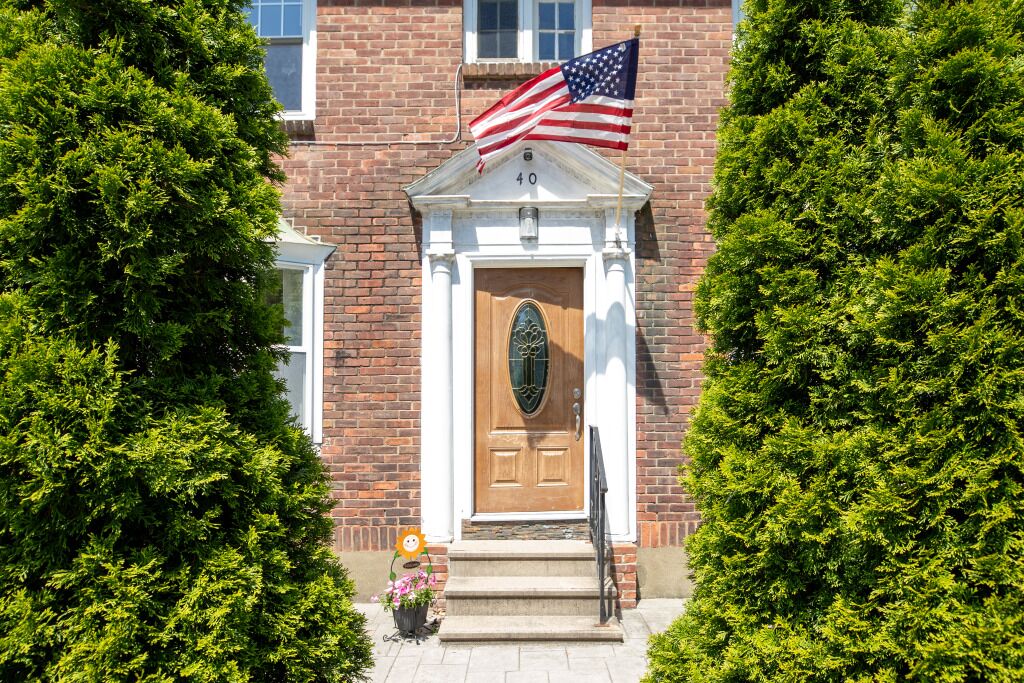 A brick building with a wooden door, an American flag, and a number "40" above the door.