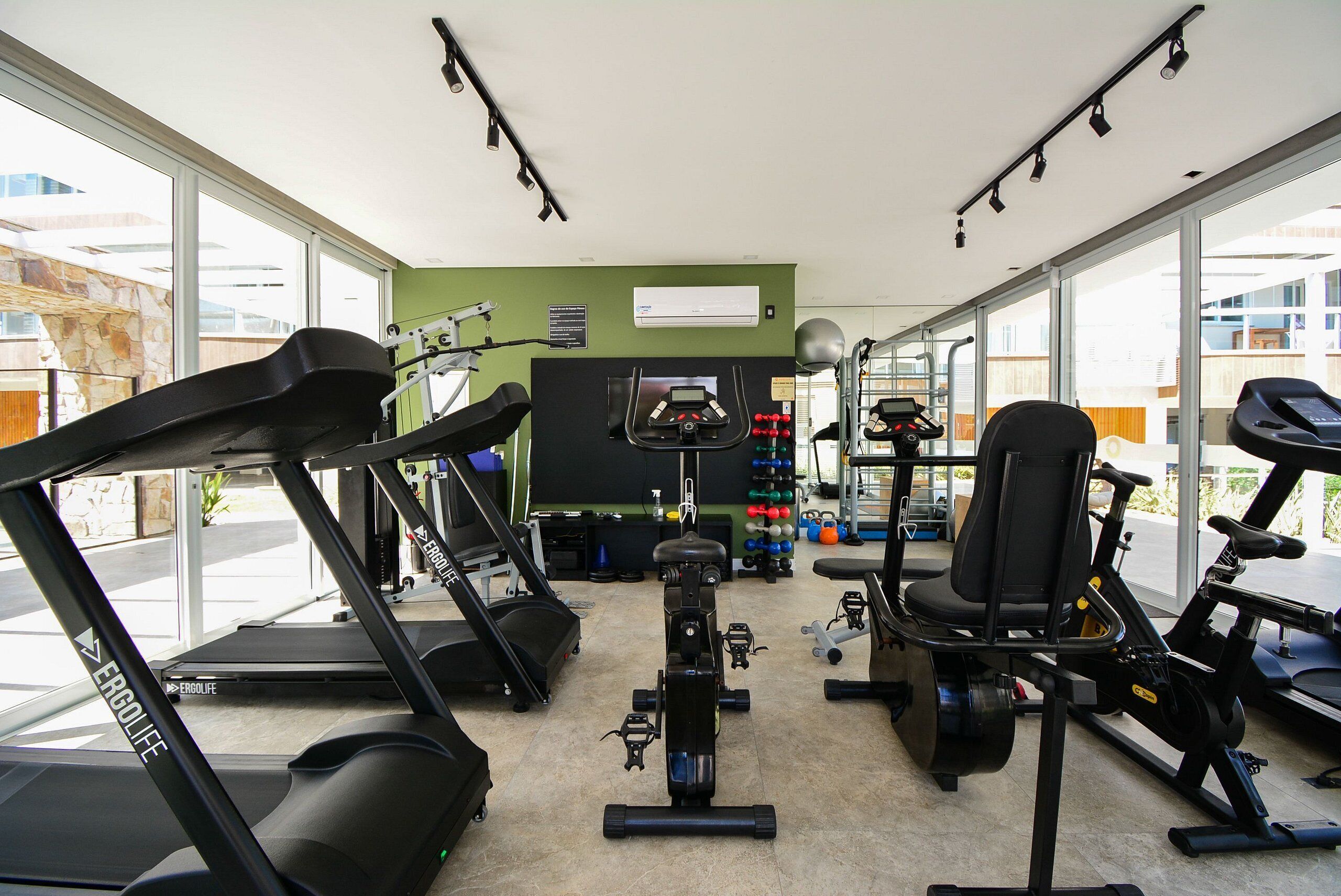 A gym with treadmills, stationary bikes, and exercise equipment.