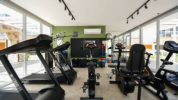 A gym with treadmills, stationary bikes, and exercise equipment.