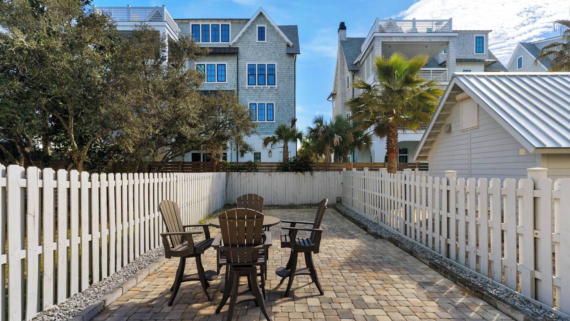 A patio with outdoor seating and a white picket fence.