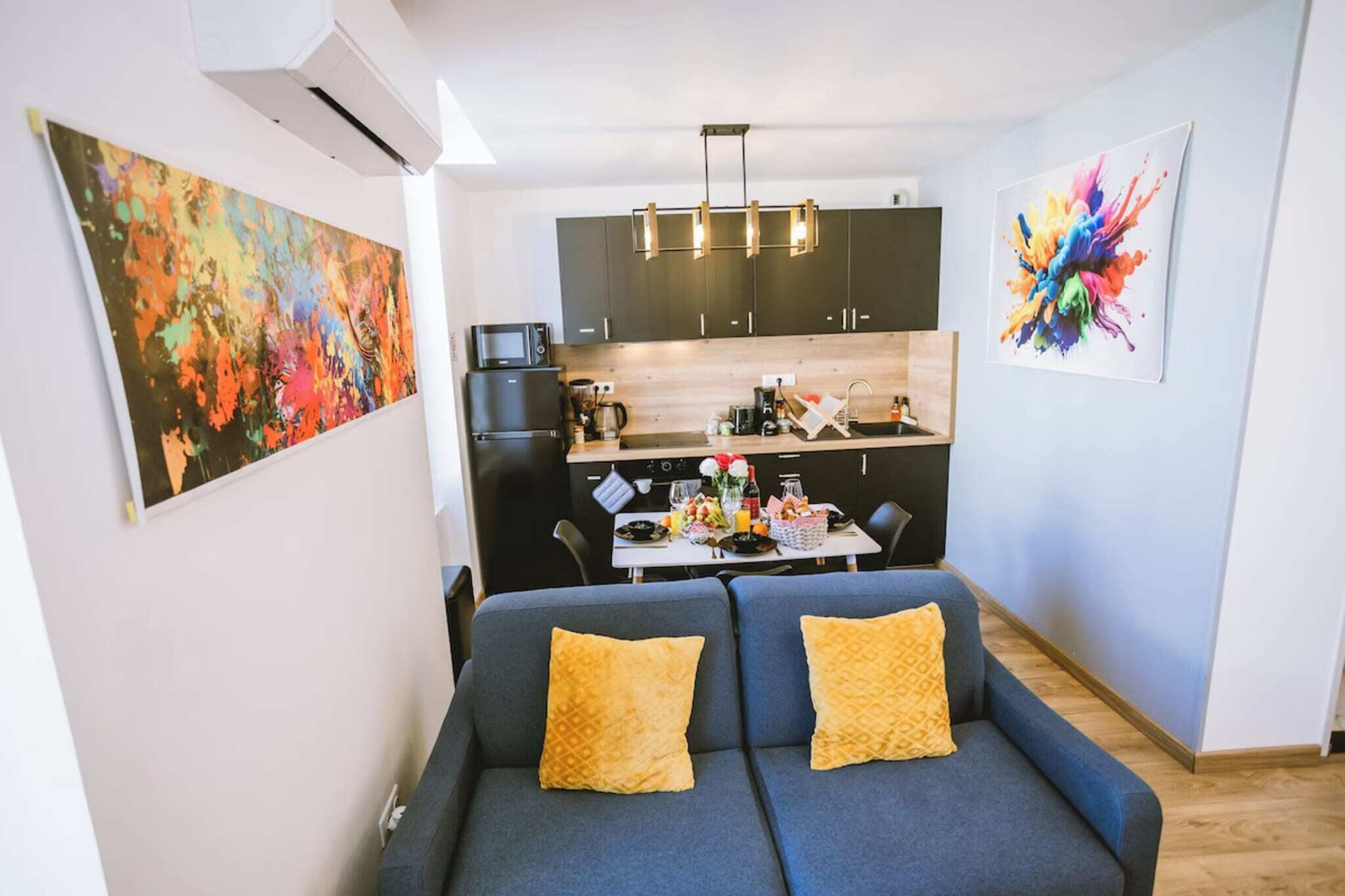 Een moderne woonkamer met een bank en een eethoek met een tafel en stoelen.