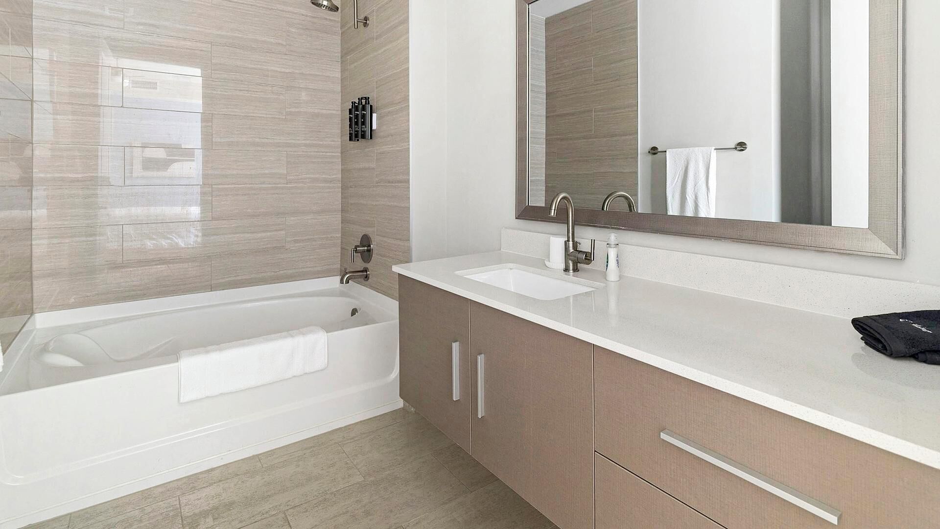 Une salle de bain moderne avec une baignoire, un lavabo et un grand miroir.