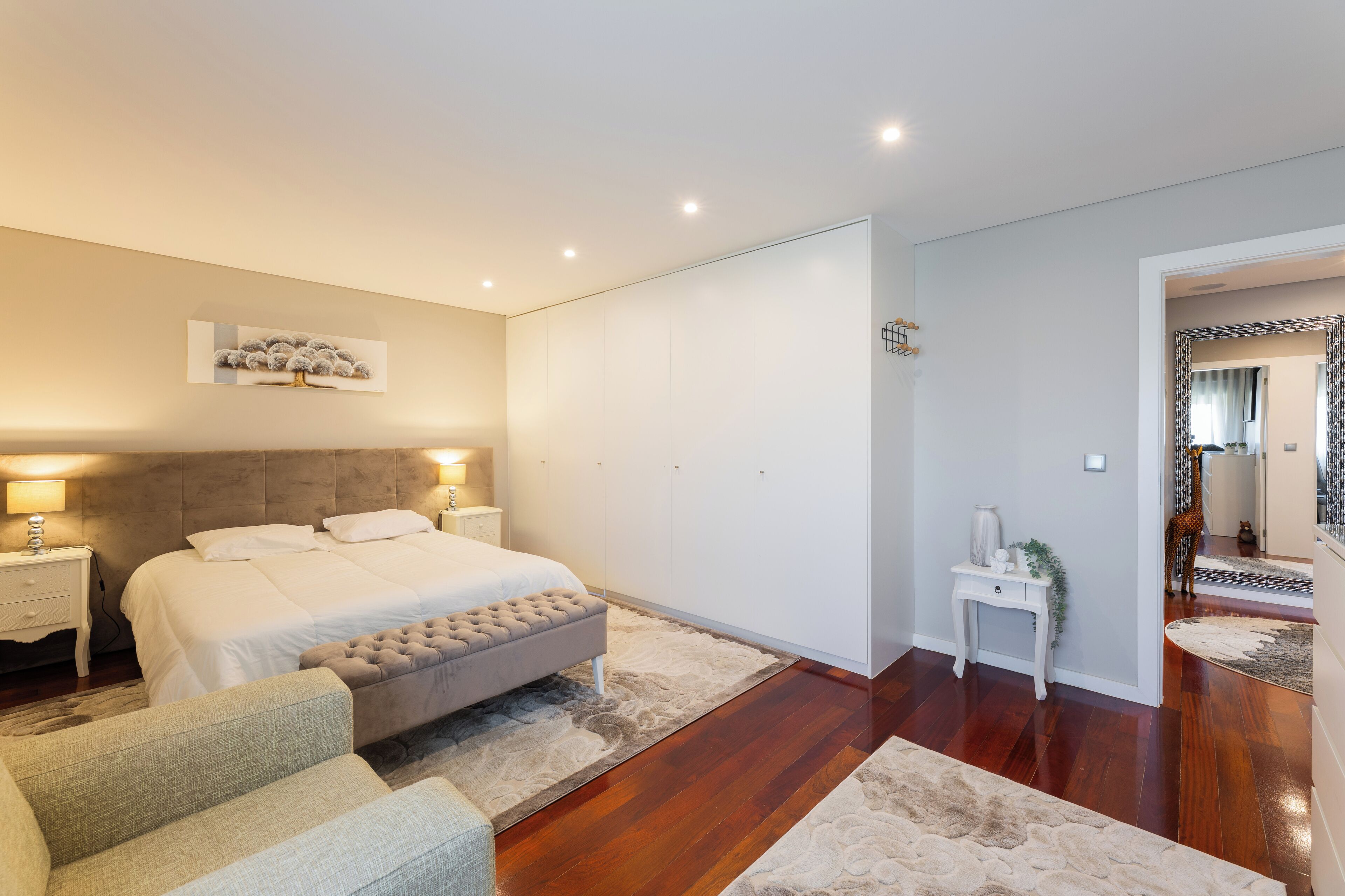 Una camera da letto moderna con un letto grande, comodini, un tavolino e uno specchio.