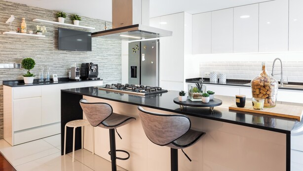 A modern kitchen with a central island, bar stools, a built-in oven, and a stainless steel refrigerator. - Spacious and comfortable apartment in Apulia, 100 m from the beach! (Apúlia)