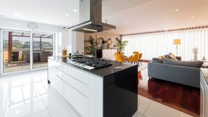 A modern kitchen with a central island, a dining area with yellow chairs, and a sofa. - Spacious and comfortable apartment in Apulia, 100 m from the beach! (Apúlia)