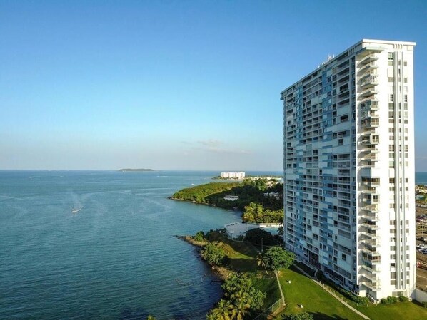 A high-rise hotel with multiple balconies, a view of the sea, and a small island in the distance. - Concho Toad Bay (Fajardo)