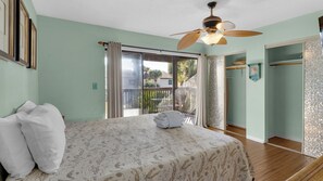 A bedroom with a bed, a ceiling fan, a sliding glass door to a balcony, and a walk-in closet. - Portside Resort D1: Gulf Retreat With Pools, Beach & Family Adventures! (Panama City Beach)