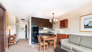 A compact living space with a dining area, kitchenette, and seating area.
