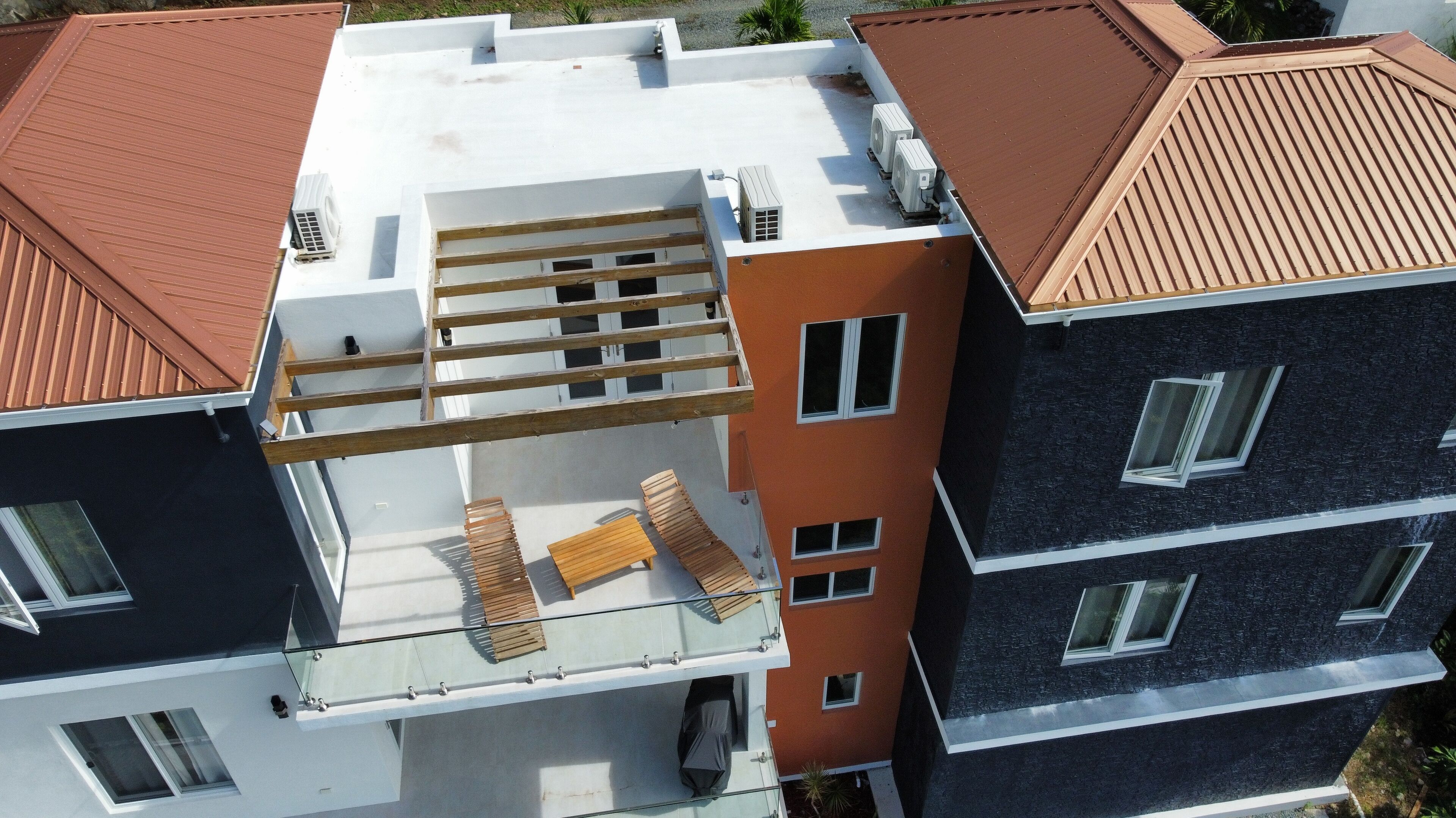 Ein mehrgeschossiges Wohngebäude mit Dachterrasse, Balkonen und modernem architektonischen Design.