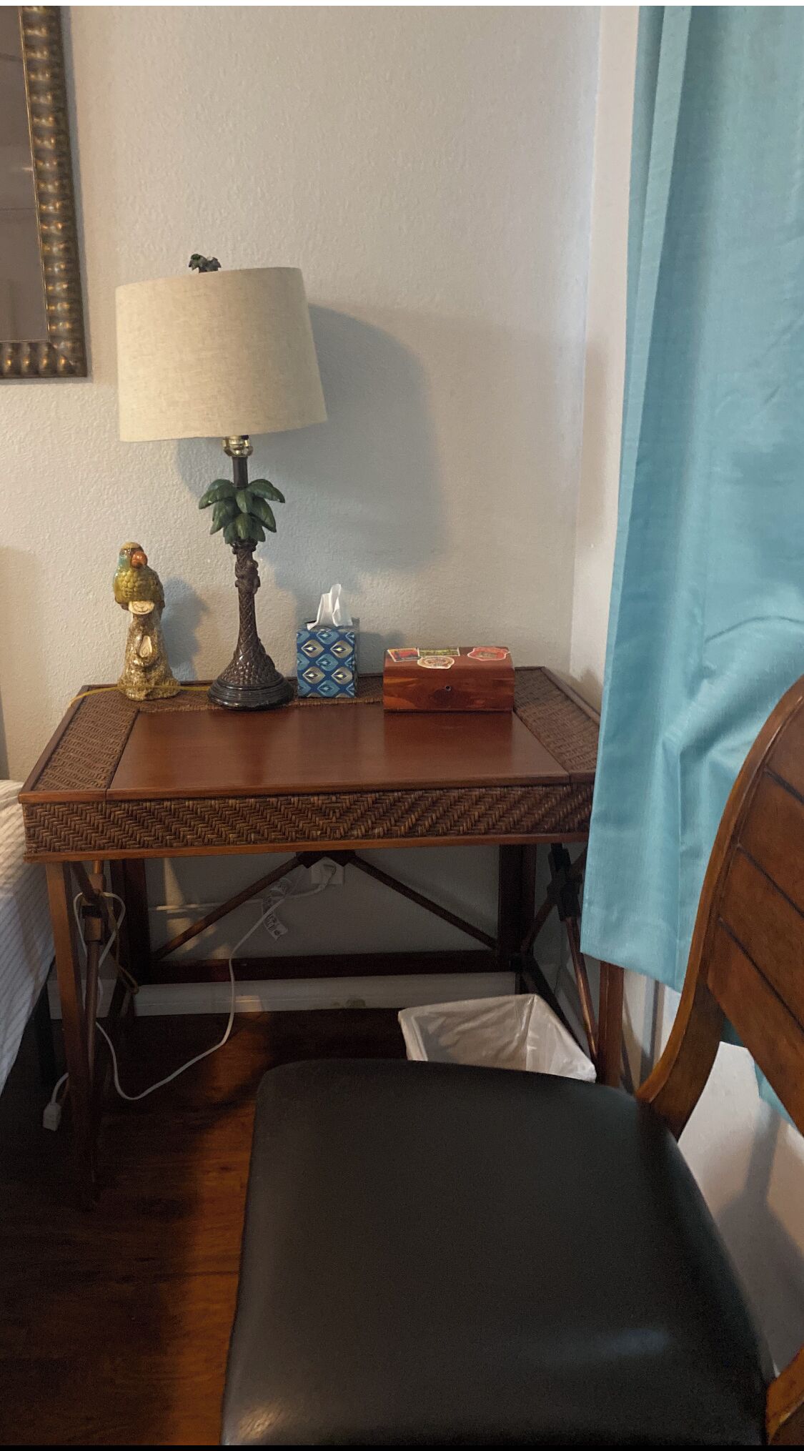 Ein kleiner Holztisch mit einer Lampe, einer Taschentuchbox und einem dekorativen Gegenstand.