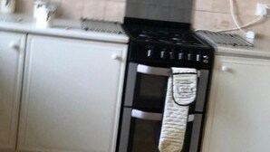 Una cocina con estufa, horno y alacenas.
