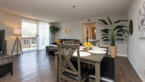 Una sala de estar moderna con una mesa de comedor, un sofá y un televisor.