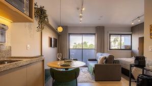 A modern apartment with a kitchen, dining area, and living space. - Essence Studio Vila Mariana | Air Conditioning, Wi-Fi & Vila Mariana Metro (São Paulo)