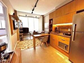 Une cuisine moderne avec des meubles en bois, un four encastré et un réfrigérateur.