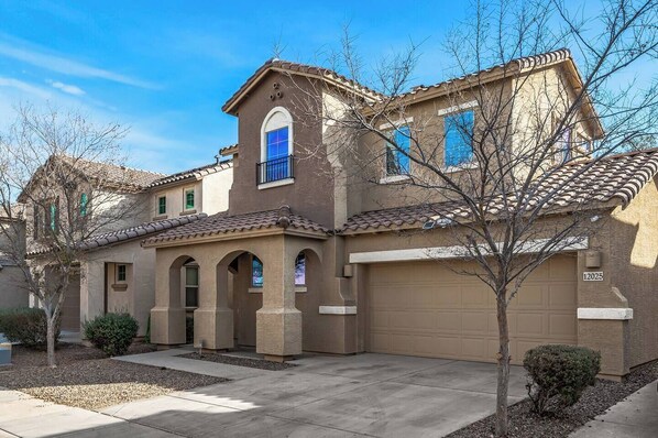A two-story house with a garage, arched windows, and a tiled roof. - Entire Home 3 bedroom 2.5 bathroom in Avondale Arizona (Avondale)