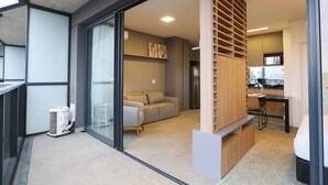 A modern interior with a sofa, a dining area, and a kitchen. - VN Millenium Faria Lima (Sao Paulo)