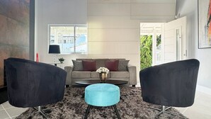 A modern living room with a sofa, two armchairs, a coffee table, and a rug. - Casa Moderna e Aconchegante  (Florianopolis)