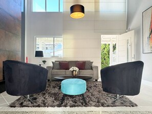 A modern living room with a sofa, two armchairs, a coffee table, and a rug. - Casa Moderna e Aconchegante  (Florianopolis)