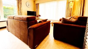 Ein Wohnzimmer mit einer Couch, einem Couchtisch und einem Fernseher.