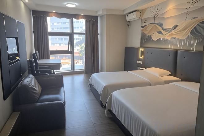 Una habitación de hotel con cama, sofá, escritorio y televisión.