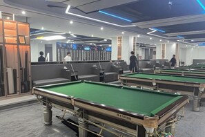 A pool hall with multiple pool tables, seating areas, and a mirrored wall. - Longteng Boutique Hotel (Shenzhen Baoneng Center Sungang Subway Station Branch) (Shenzhen)