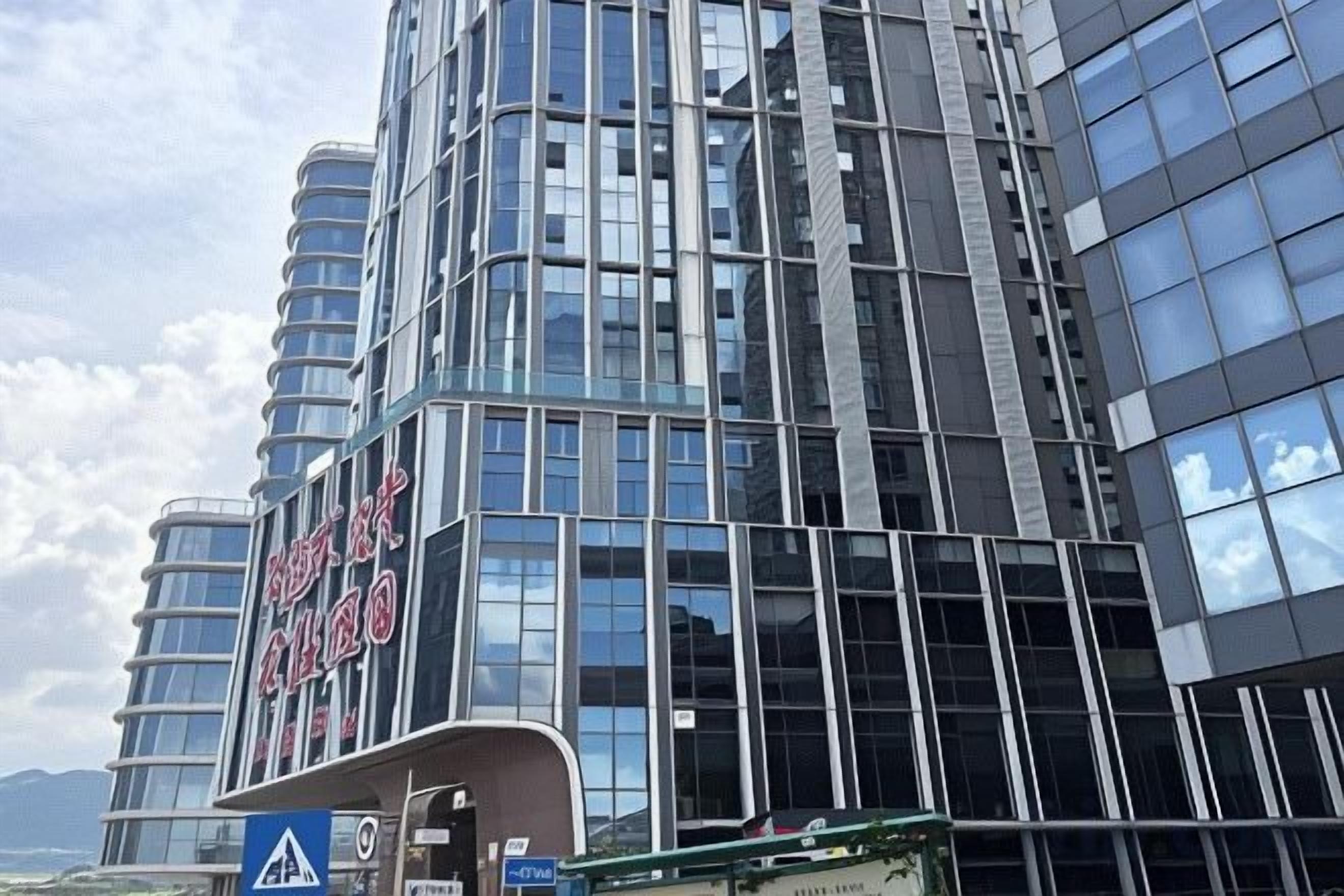 A multi-story building with a modern architectural design, featuring large windows and a prominent signage.