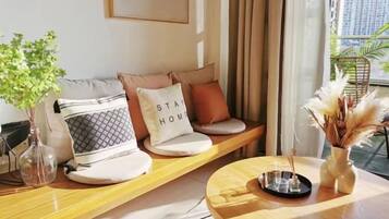 A modern living room with a sofa set, a coffee table, and a vase with dried plants.