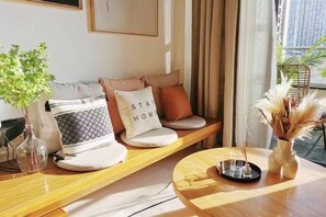 A modern living room with a sofa set, a coffee table, and a vase with dried plants. - Longteng Boutique Hotel (Shenzhen Baoneng Center Sungang Subway Station Branch) (Shenzhen)