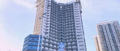 Un immeuble à plusieurs étages, dont la façade est ornée d’une grande horloge, et qui est probablement un hôtel ou un immeuble de bureaux.