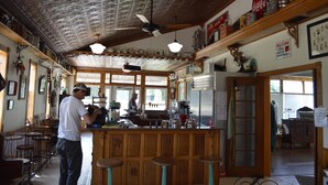 A restaurant with a bar area, wooden ceiling, and various kitchen appliances. - Pet-Friendly Family Home near Golf, LK MI, M22 (Arcadia)