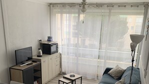 A compact living space with a bed, a small kitchenette, a sofa, and a dining table. - Solydays Floralies duplex for 6 people near the beach (Le Grau-du-Roi)