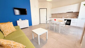 A modern apartment with a living area, kitchenette, and dining space. - Appartamento Dante  (Prato)