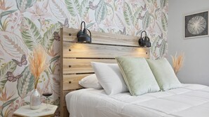 A bedroom with a wooden headboard, white bedding, and a small bedside table with a vase and wine glass. - Near Ithaca!Hot Tub! LRG Home!Sleeps 12! Dogs ok! (Newfield)
